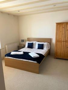 a bedroom with a bed with blue and white pillows at The Cottage, Hill Top Stables in Esh