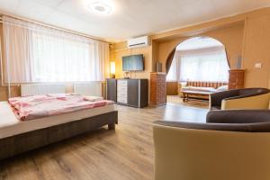 ヴィシェグラードにあるVisegrád Vendégház-Apartmanのベッドとリビングルームが備わるホテルルームです。