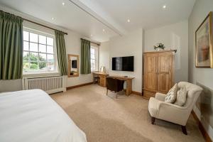 a bedroom with a bed and a desk and a television at Serviced Apartments Macclesfield in Macclesfield