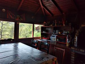 een keuken met een tafel en een aantal ramen bij Casa Savu Secaria in Secăria
