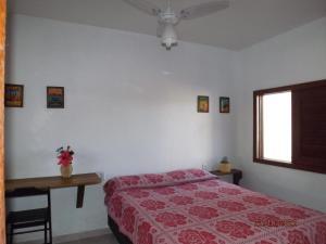 a bedroom with a bed and a table and a window at Chalé Sunset Taipu de Fora in Marau