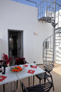 a white table with a bowl of fruit and wine glasses at Pérola Azul in Lagos