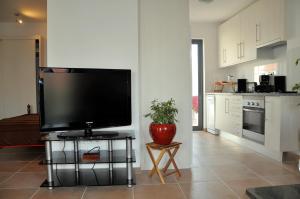 a living room with a flat screen tv on a table at Pérola Azul in Lagos +11 photos