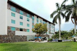 un edificio con palmeras delante en Holiday Inn Express Villahermosa, an IHG Hotel, en Villahermosa