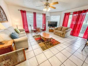 a living room with red curtains and a couch and a tv at Comal River Condo 373 in New Braunfels