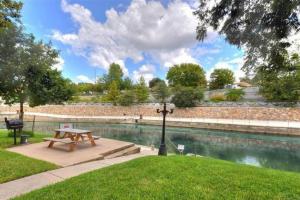 a picnic table in a park next to a pond at Comal River Condo 373 in New Braunfels