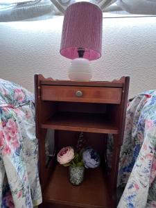 a nightstand with a lamp on top of a bed at Casa Rural Xauen in Belicena