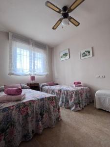 a bedroom with two beds and a ceiling fan at Casa Rural Xauen in Belicena