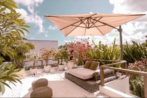 a patio with an umbrella and chairs and plants at Sunset Palms Beach Villa in Jimbaran
