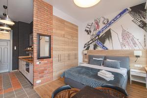 a bedroom with a bed and a brick wall at Modern Vilnius Old Town apartment with free parking in Vilnius