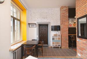 a kitchen with a table and chairs and a brick wall at Modern Vilnius Old Town apartment with free parking in Vilnius