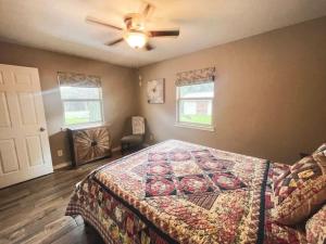 um quarto com uma cama e uma ventoinha de tecto em The Retreat at Oak Acres Guest House em New Braunfels