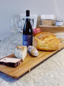 ein hölzernes Schneidebrett mit Brot und einer Flasche Wein in der Unterkunft Casa da Bertu in Barbaresco