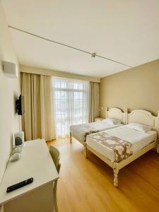 um quarto com 2 camas, uma mesa e uma secretária em Monte Verde em Funchal