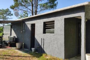 a small white building with an open door at Cuchilla Alta-La Cabaña Celeste in Cuchilla Alta
