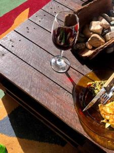 um copo de vinho sentado ao lado de um prato de comida em La Cabaña Celeste em Cuchilla Alta