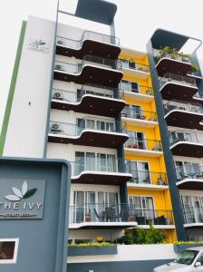 a tall apartment building with a sign in front of it at Premier Executive Apartment - The Ivy, East Legon in Accra