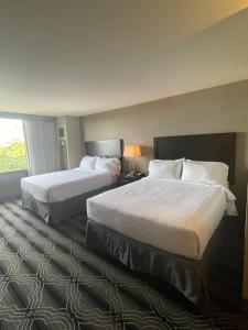 勞雷爾山的住宿－Grand Resort Hotel - Mt Laurel - Philadelphia，酒店客房设有两张床和窗户。