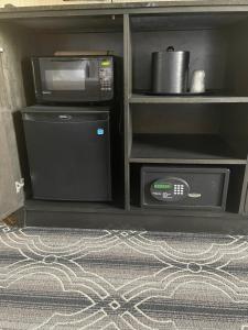 a kitchen with a microwave and a stove and a refrigerator at Grand Laurel Hotel in Mount Laurel