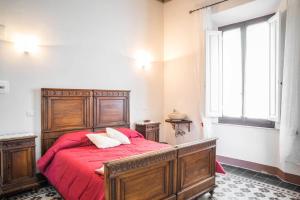 Un dormitorio con una cama con sábanas rojas y una ventana en La Chicca B&B Siena, en Siena
