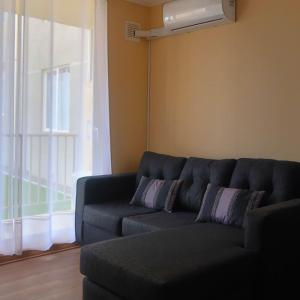 塔爾卡的住宿－Departamento Exclusivo Talca，客厅设有蓝色的沙发和窗户。