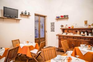 una sala da pranzo con 2 tavoli e una cucina di La Chicca B&B Siena a Siena