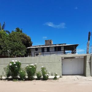 una casa con garaje frente a una valla en Ap 04-A 50 Metros da Praia Flats Completamente Mobiliados, en Paulista