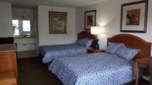 una camera d'albergo con due letti e una finestra di Ambassador Inn a Kissimmee