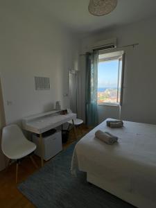 1 dormitorio con cama, escritorio y ventana en Guest House Enny, en Dubrovnik