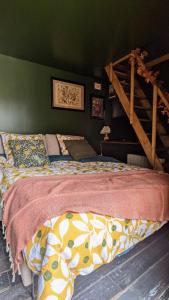 Ce lit se trouve dans une chambre dotée d'un mur vert. dans l'établissement Le Cottage et la Tiny des Cartes - 2 maisons, à LʼÎle Bouchard
