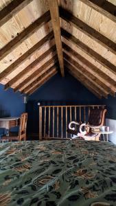 - une chambre avec un grand lit et des plafonds en bois dans l'établissement Le Cottage et la Tiny des Cartes - 2 maisons, à LʼÎle Bouchard