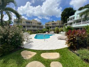 a courtyard with a swimming pool and a resort at 25 Margate Gardens in Bridgetown