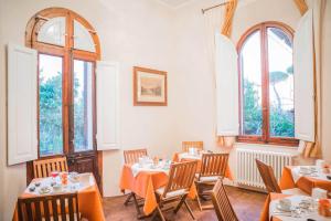 un restaurante con mesas, sillas y ventanas en La Chicca B&B Siena, en Siena