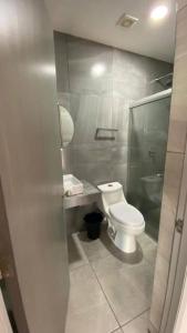 ein Badezimmer mit einer weißen Toilette und einem Waschbecken in der Unterkunft Habitación hotelera 5min de la playa by G P S rentas in Mazatlán + 10 Fotos