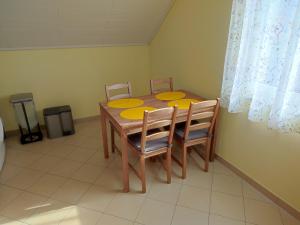 a dining room table with four chairs and yellow plates on it at 1-Zimmer-Wohnung Nähe Playmobil Funpark in Oberasbach