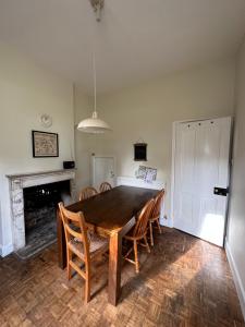 a dining room with a wooden table and chairs at Historic 2 bed gatehouse in private parkland in Brockenhurst