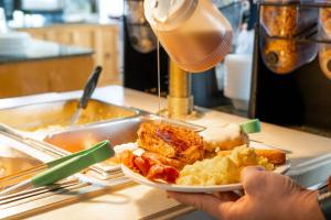 a person holding a plate of food on a counter at Parry Lodge in Kanab