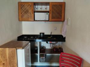 a small kitchen with a stove and a sink at Reserva Rede e Mar - Rota dos Milagres - Patacho in Pôrto de Pedras