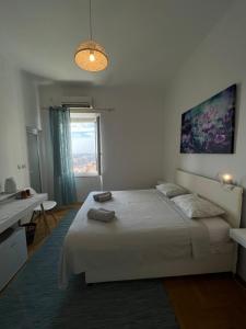 a white bedroom with a bed and a window at Guest House Enny in Dubrovnik