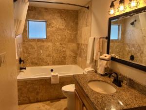 a bathroom with a tub and a toilet and a sink at TimberLodge Inn in Pinetop-Lakeside