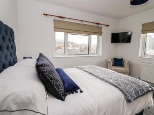 a bedroom with a large white bed with blue pillows at Ty Melyn in Aberystwyth
