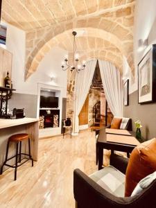ein Wohnzimmer mit einem Sofa und einem Tisch in der Unterkunft 300yr old, self catering, tiny house in Victoria Centre, Gozo in Victoria