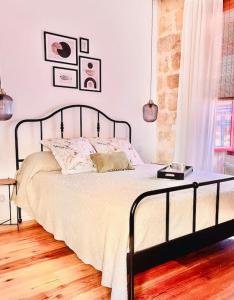 - une chambre dotée d'un lit avec un cadre noir dans l'établissement 300yr old, self catering, tiny house in Victoria Centre, Gozo, à Victoria