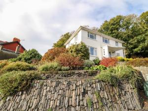 a house with a stone retaining wall and a garden at Ty Melyn in Aberystwyth