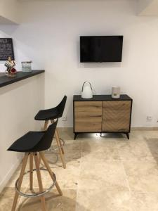 Pokój z dwoma krzesłami i telewizorem na ścianie w obiekcie Gite Le petit Relais w mieście Mer