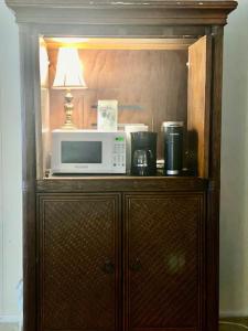 a microwave sitting on top of a wooden cabinet at Reef Dreamer Artist’s Retreat in Gulf Breeze