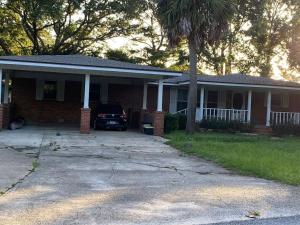 a house with a car parked in the driveway at Reef Dreamer Artist’s Retreat in Gulf Breeze