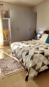 1 dormitorio con 1 cama grande y edredón blanco y negro en Divjaka Apartments 2 - City Center, en Divjakë