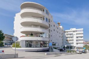 - un bâtiment blanc avec des balcons sur le côté dans l'établissement City East Apartment, à Split