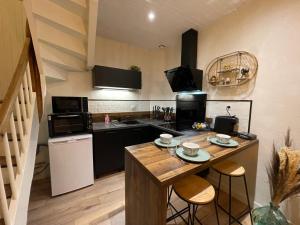 eine Küche mit einem Holztisch und einer Arbeitsplatte in der Unterkunft Joli cocon en hyper centre in Loudéac